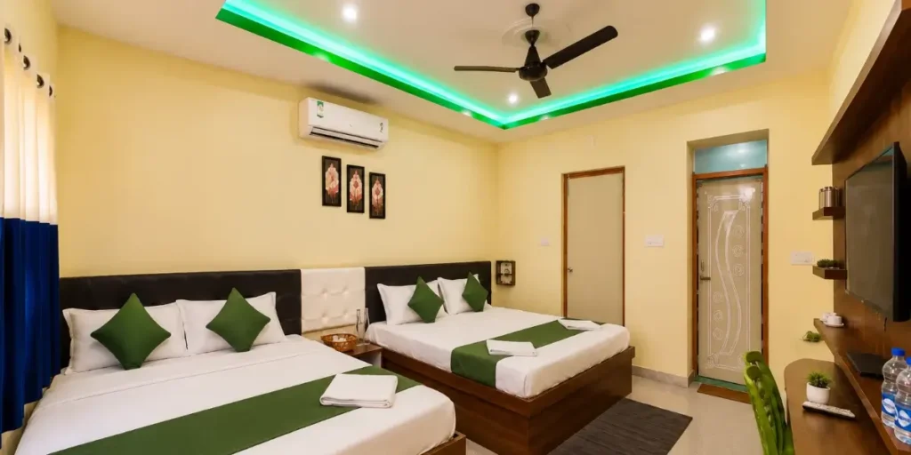Herit Eco Resort room with two double beds and green bedding accents